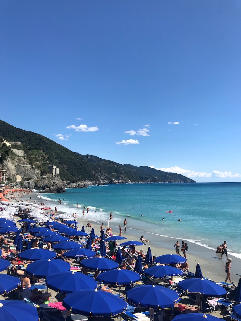 Parasols en ligbedden op het strand van Monterosso al Mare