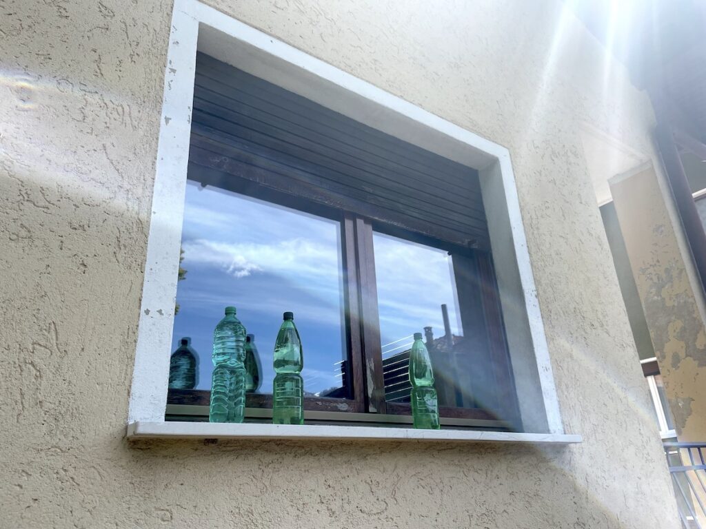 Flessen water voor de deur of bij het raam in Italië