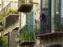 oude man kijkt vanaf balkon in Palermo naar beneden