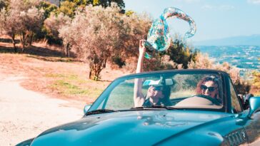 twee vrouwen in een cabrio, rijdend oor het Italiaanse landschap