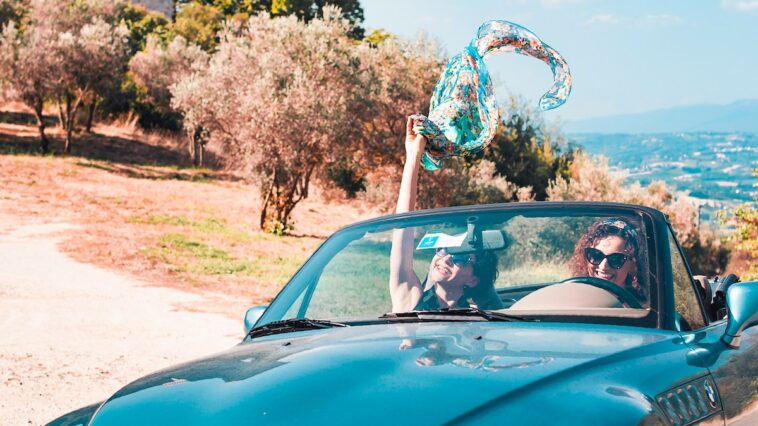 twee vrouwen in een cabrio, rijdend oor het Italiaanse landschap
