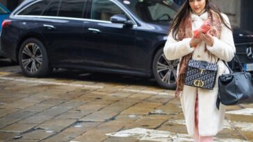 Chic gekleed gaande vrouw op een zebrapad in Milaan in de winter