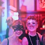 Gemaskerde vrouwen tijdens een feest